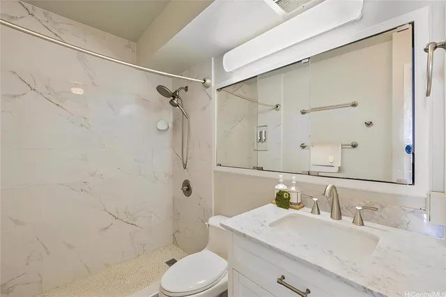 a bathroom with a granite countertop sink toilet and shower