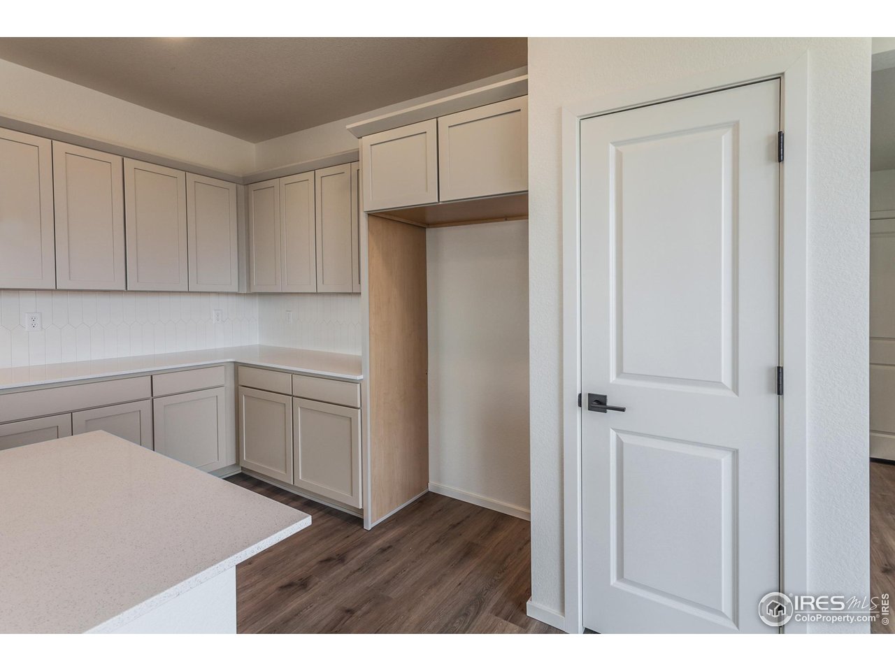 5701 Stone Fly Drive Timnath, CO 80547 - Photo 10 of 48 a kitchen with white cabinets and white appliances