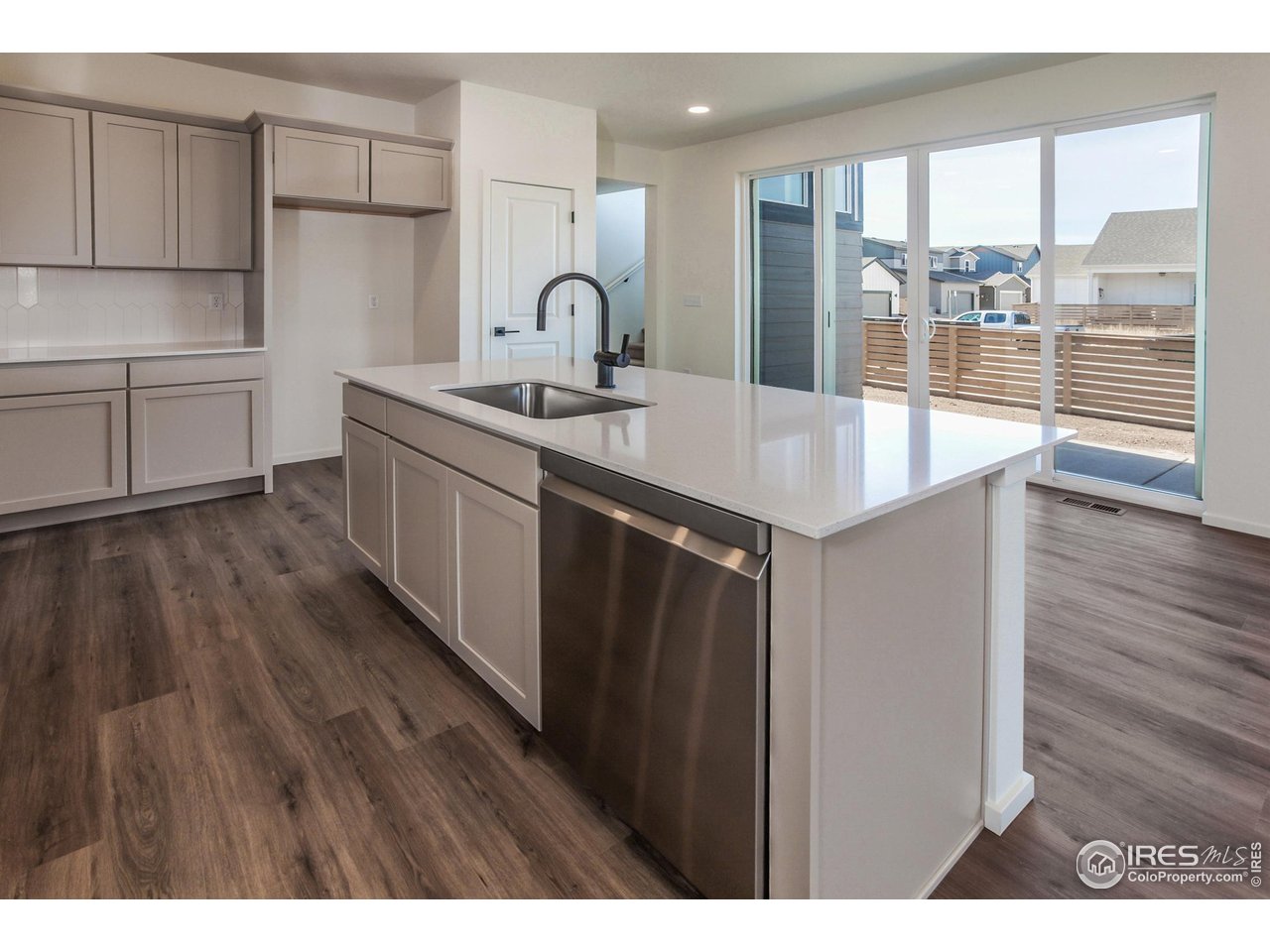 5701 Stone Fly Drive Timnath, CO 80547 - Photo 13 of 48 a kitchen with kitchen island a sink a stove and wooden floor