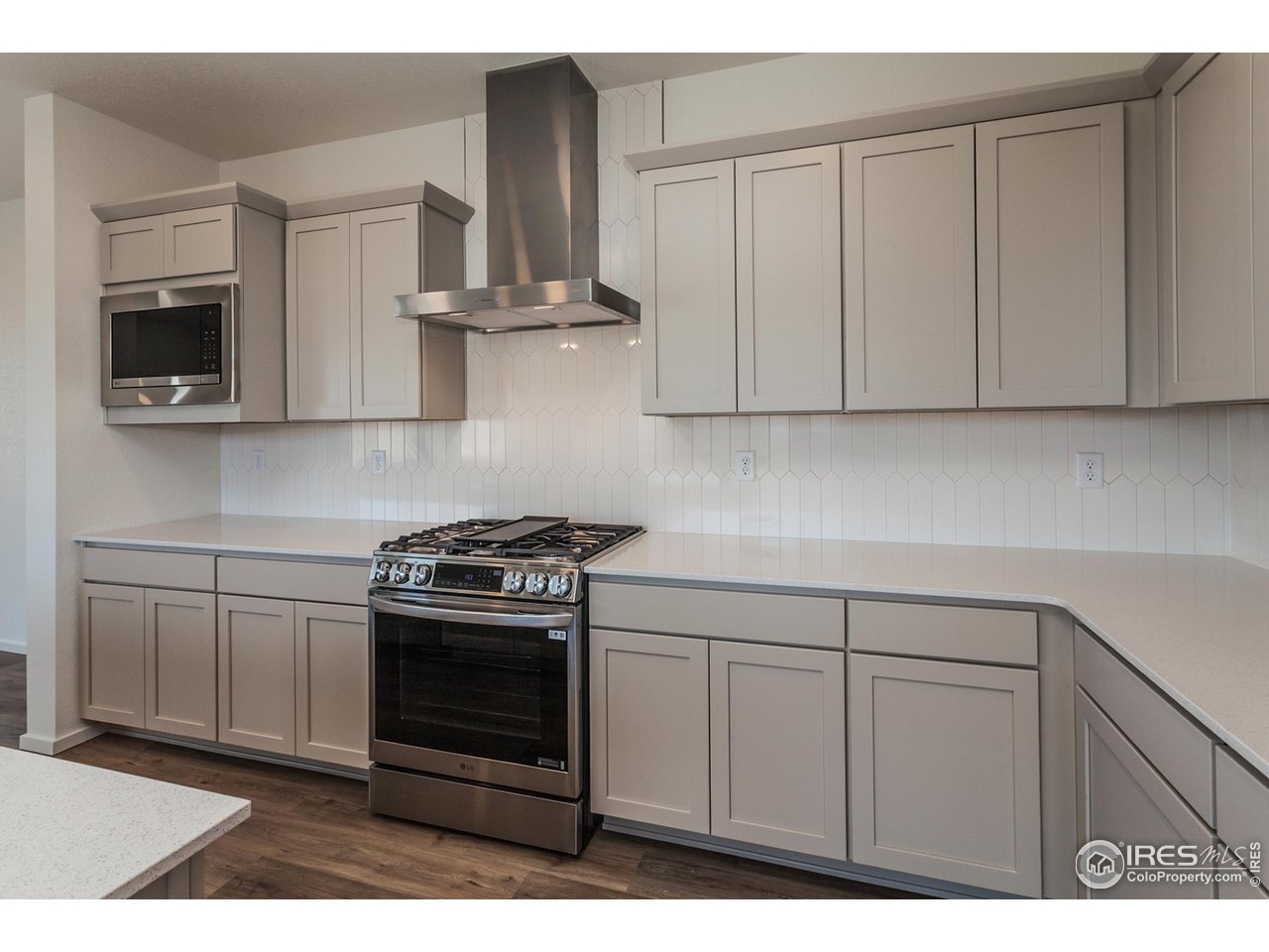 5701 Stone Fly Drive Timnath, CO 80547 - Photo 14 of 48 a kitchen with stainless steel appliances granite countertop a stove a microwave and cabinets