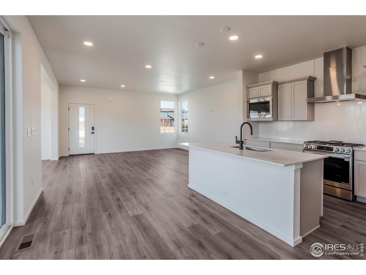 5701 Stone Fly Drive Timnath, CO 80547 - Photo 7 of 48 a kitchen with kitchen island a sink stainless steel appliances and cabinets
