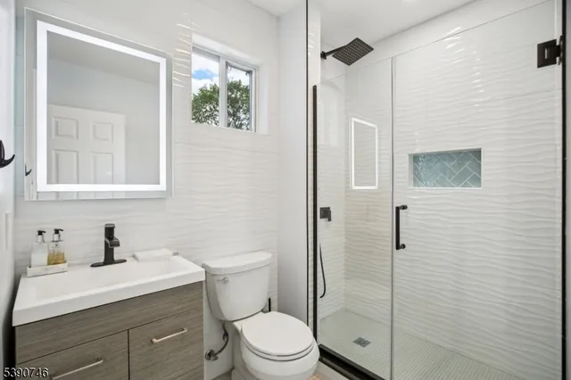 a bathroom with a sink a toilet and shower