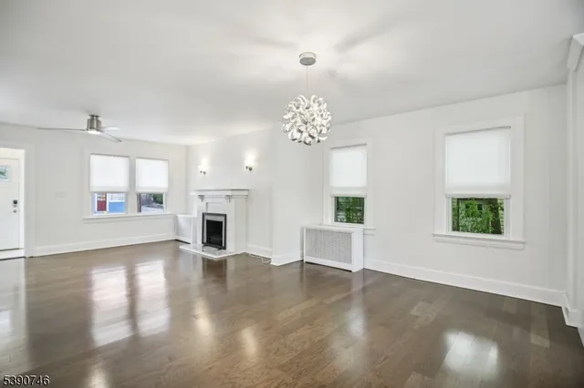 a view of a livingroom with a fireplace wooden floor and windows