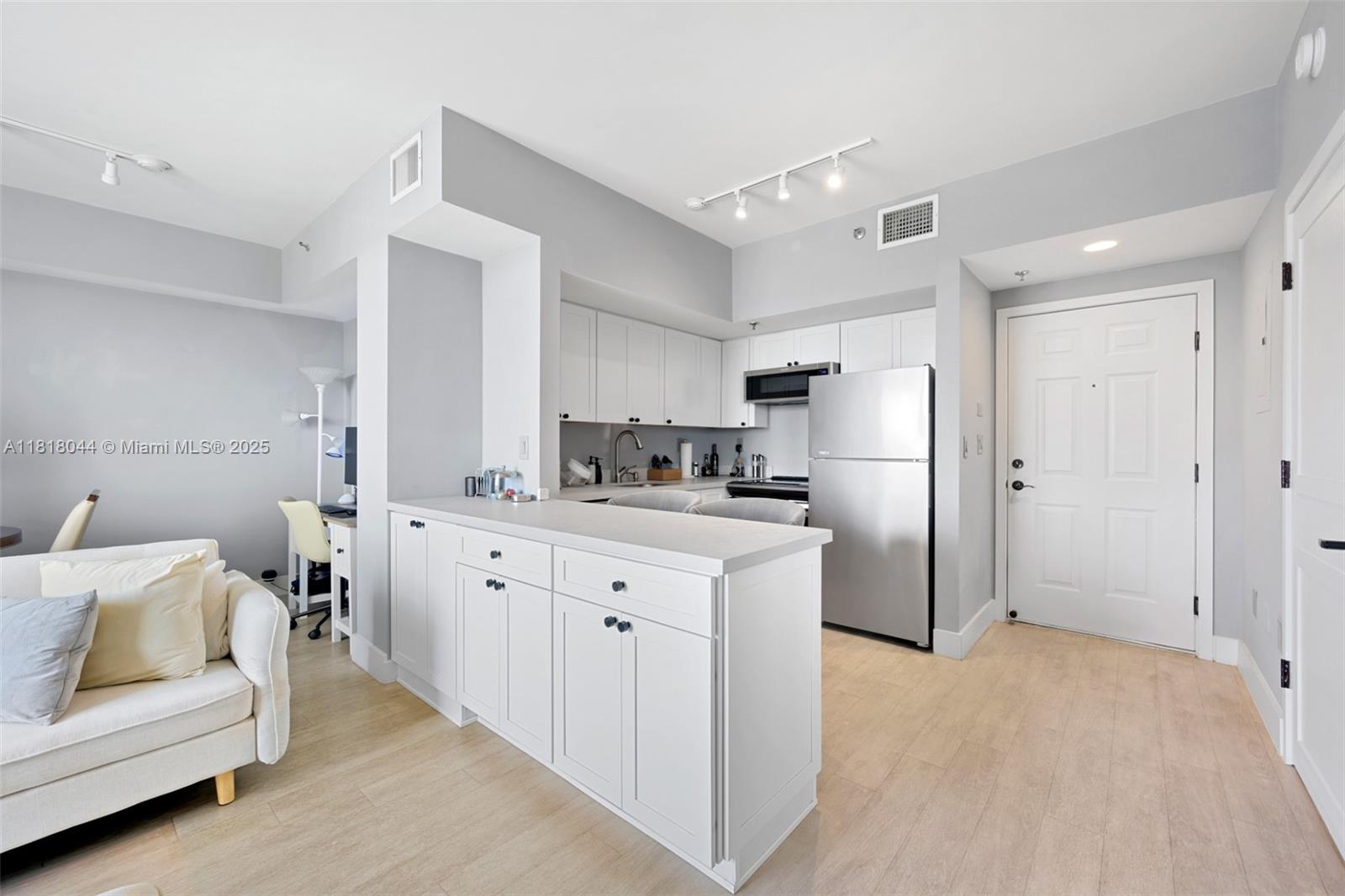 1621 Bay Road, Unit PH3 Miami Beach, FL 33139 - Photo 8 of 24 a kitchen with white cabinets and refrigerator