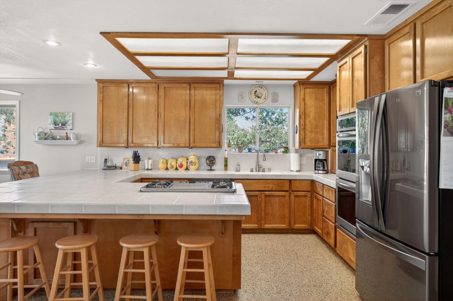 28037 Sky Harbour Road Friant, CA 93626 - Photo 9 of 40 a kitchen with stainless steel appliances granite countertop a refrigerator and a sink