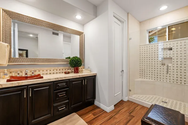 a view of a patio with couches potted plants and palm trees
