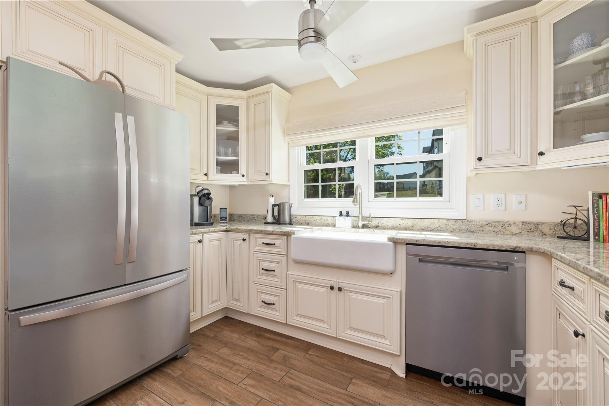 5431 Park Road Charlotte, NC 28209 - Photo 5 of 26 a kitchen with granite countertop a refrigerator a sink dishwasher a stove and white cabinets with wooden floor