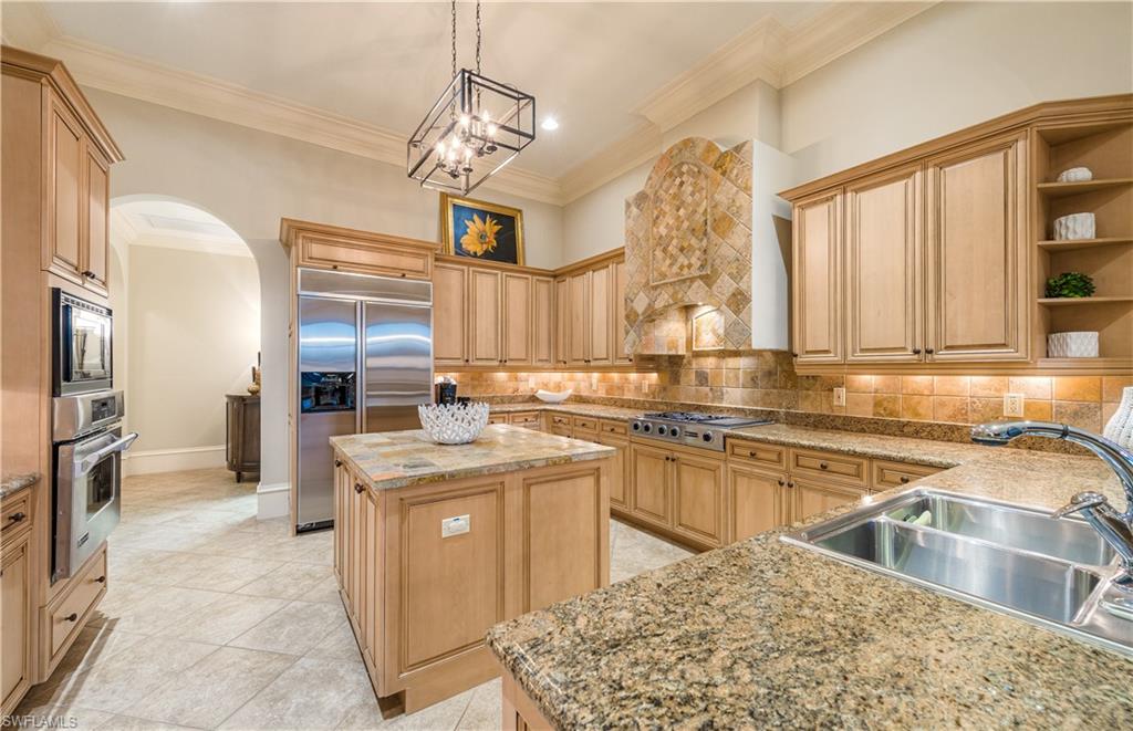 2829 Capistrano Way Naples, FL 34105 - Photo 11 of 35 a kitchen with stainless steel appliances granite countertop a sink stove and refrigerator