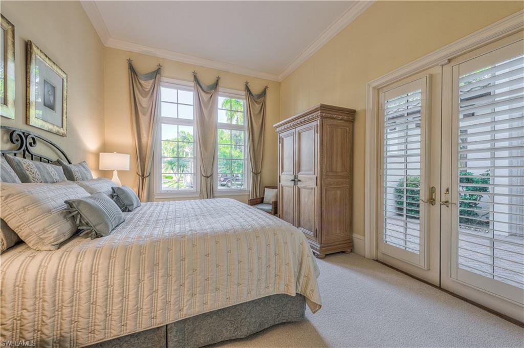 2829 Capistrano Way Naples, FL 34105 - Photo 24 of 35 a bedroom with a large bed and a large window