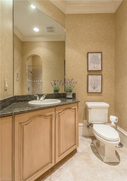 2829 Capistrano Way Naples, FL 34105 - Photo 25 of 35 a bathroom with a granite countertop toilet sink and mirror