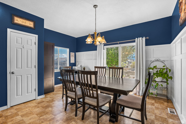 7092 Cherokee Street Eagle Mountain, UT 84005 - Photo 5 of 27 Spacious dining area featuring two-tone walls with white wainscoting and a deep blue upper section
