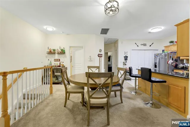 a view of a dining room and livingroom with furniture a rug a chandelier and wooden floor