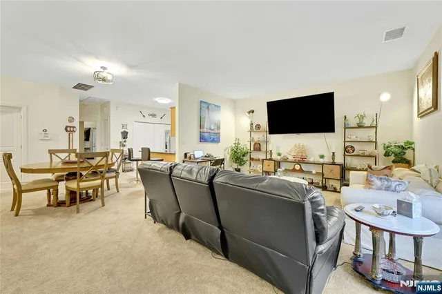 a living room with furniture a flat screen tv and a dining table