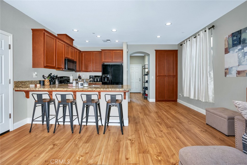 2936 Dillon Lane Merced, CA 95348 - Photo 11 of 34 a open kitchen with stainless steel appliances granite countertop a stove top oven a sink and a dining table with wooden floor