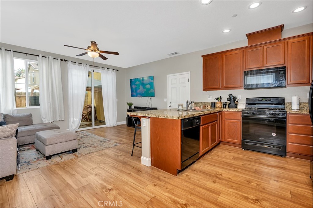 2936 Dillon Lane Merced, CA 95348 - Photo 5 of 34 a kitchen with stainless steel appliances granite countertop wooden cabinets a sink a stove a dining table and chairs