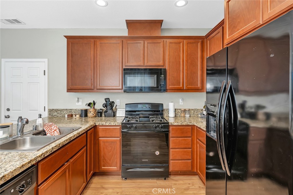 2936 Dillon Lane Merced, CA 95348 - Photo 6 of 34 a kitchen with stainless steel appliances granite countertop a stove a refrigerator and a sink