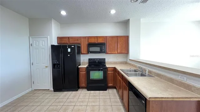 a view of kitchen with microwave and refrigerator