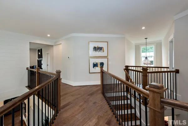 a view of a hallway with wooden floor and stairs