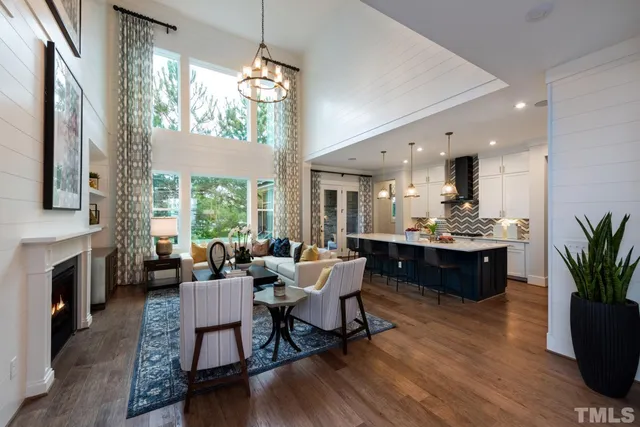 a living room with furniture dining table a flat screen tv and a fireplace
