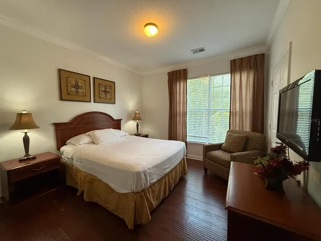 a bedroom with a bed and a flat screen tv