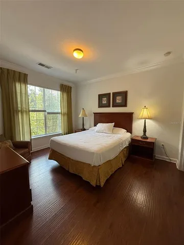 a bedroom with a bed and wooden floor