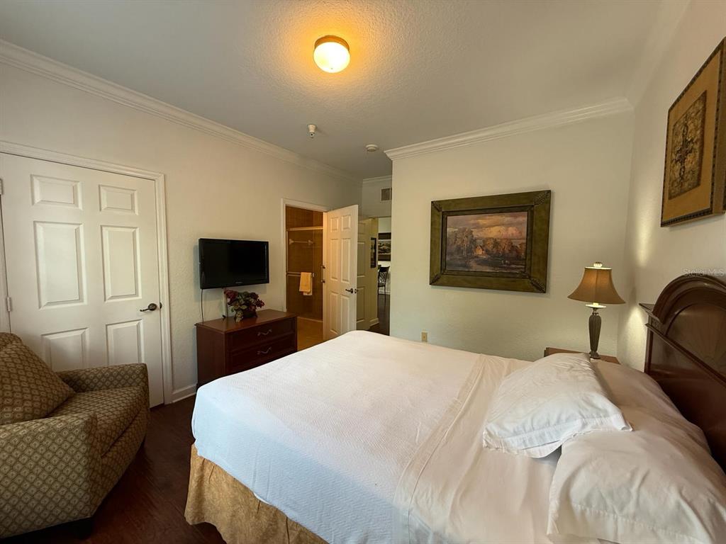 1361 Tuscan Terrace, Unit 7307 Davenport, FL 33896 - Photo 10 of 22 a bedroom with a bed a couch and a flat screen tv