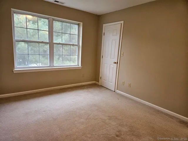 an empty room with windows and closet