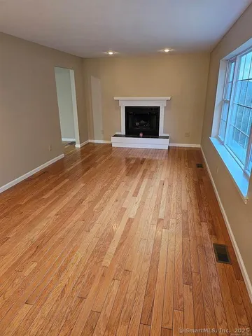wooden floor in an empty room with a fireplace