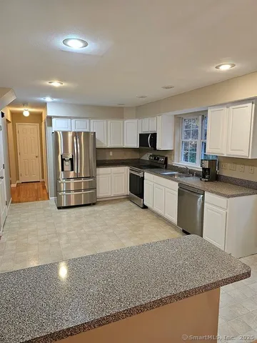 a kitchen with granite countertop a sink and stainless steel appliances