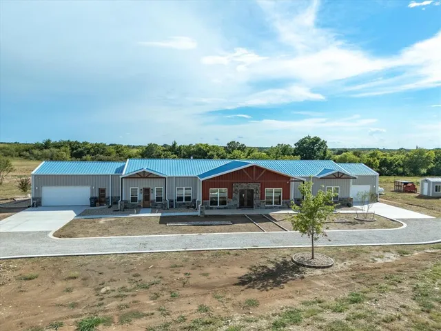 a view of a big house with a big yard and large tree