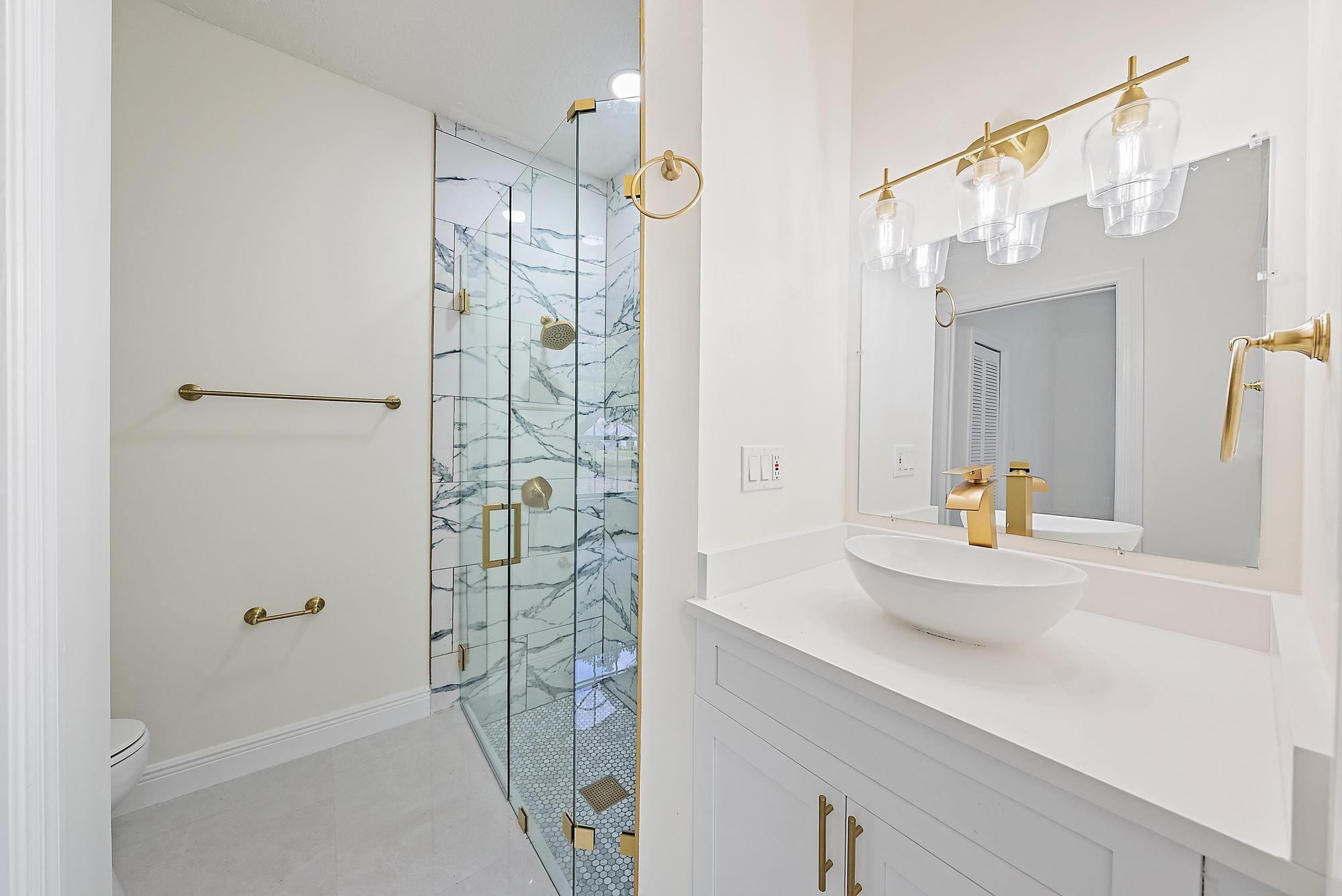 19558 Red Gum Trail Jupiter, FL 33458 - Photo 15 of 34 a bathroom with a shower sink and mirror