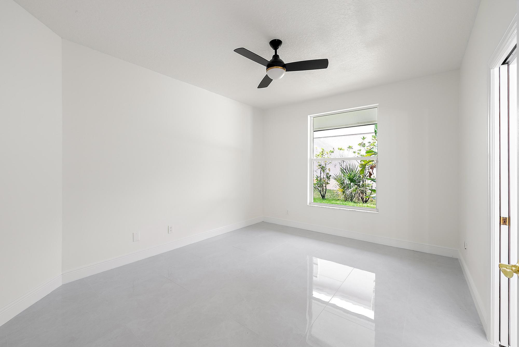 19558 Red Gum Trail Jupiter, FL 33458 - Photo 20 of 34 an empty room with windows and ceiling fan