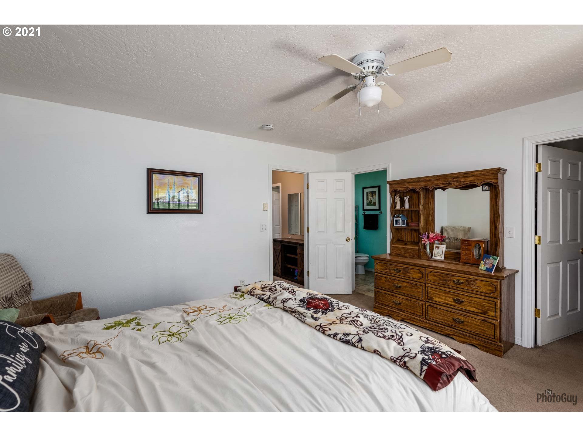 7277 Forsythia Street Springfield, OR 97478 - Photo 21 of 29 a bedroom with a large bed and a chandelier