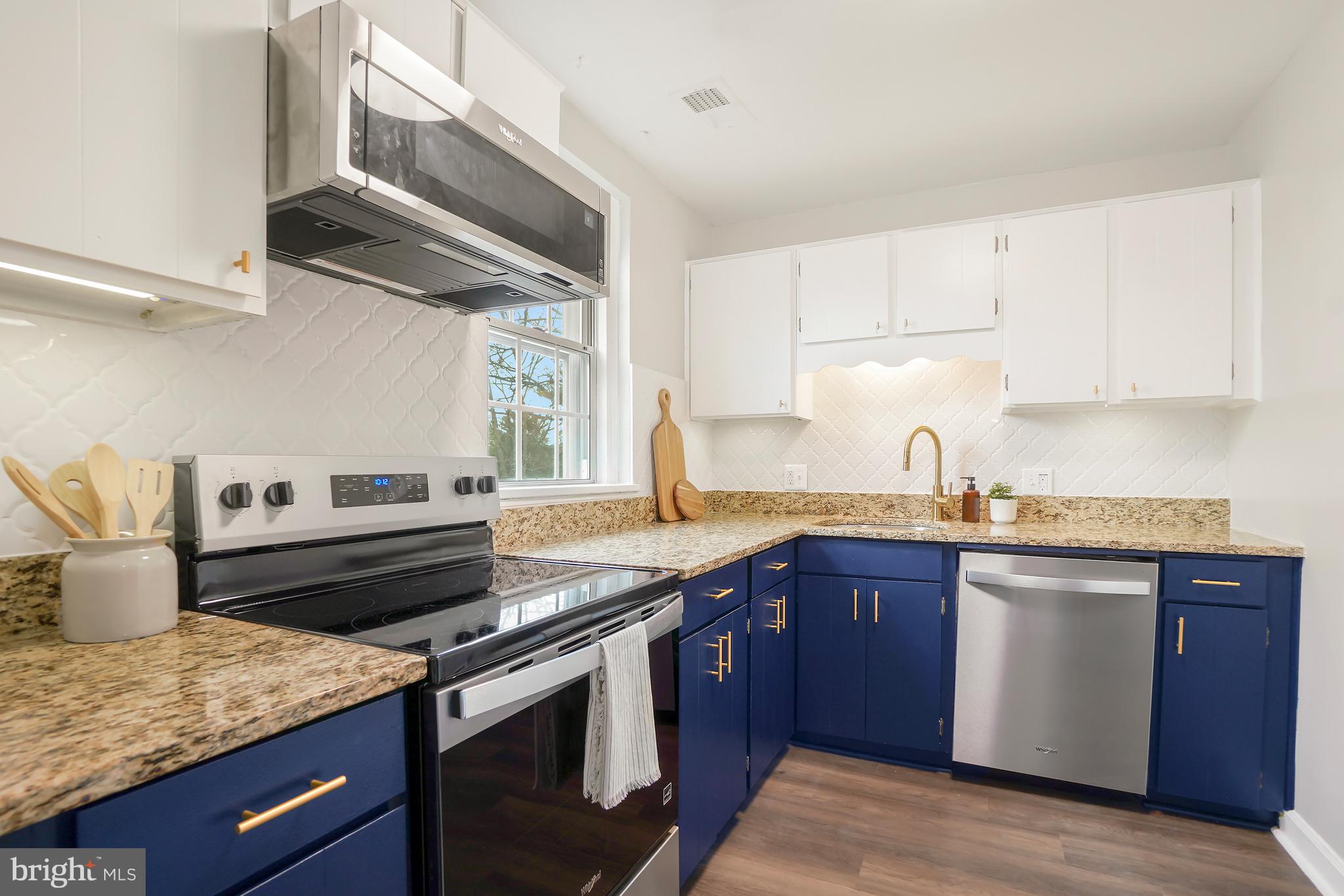 4905 29th Road South, Unit B1 Arlington, VA 22206 - Photo 11 of 52 a kitchen with kitchen island granite countertop a sink stainless steel appliances and cabinets