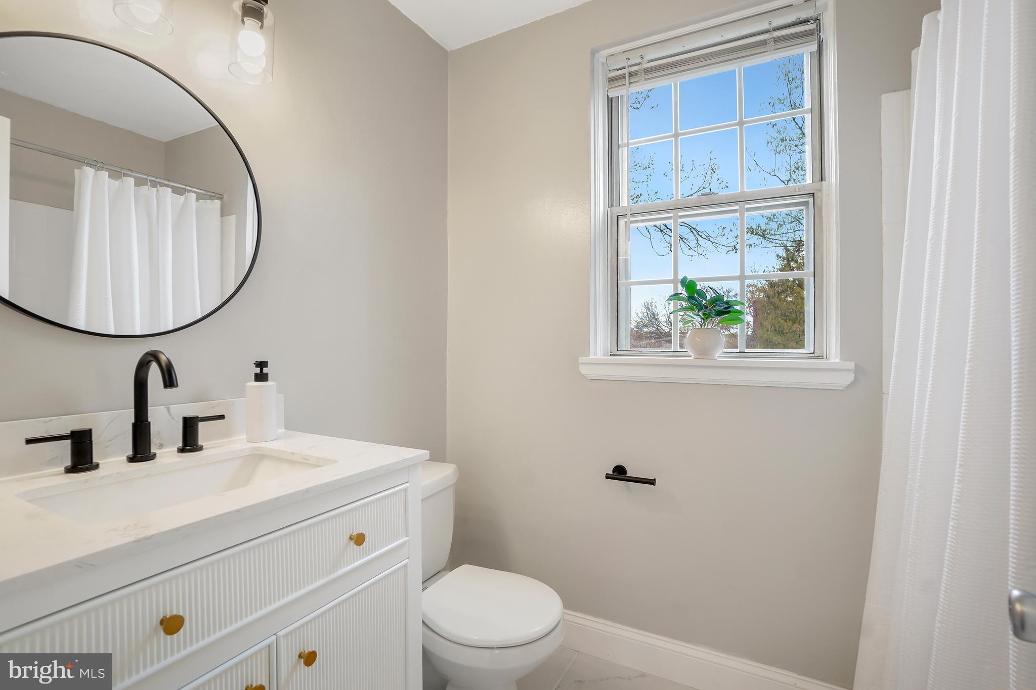4905 29th Road South, Unit B1 Arlington, VA 22206 - Photo 21 of 52 a bathroom with a sink a mirror a toilet and a window