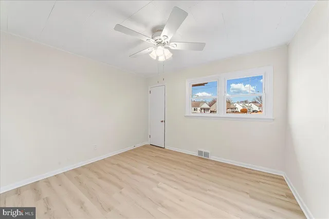 a view of a big room with wooden floor and a ceiling fan