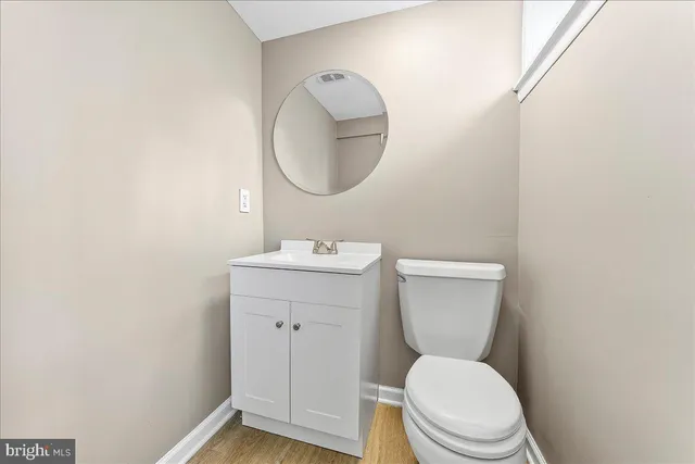 a bathroom with a toilet a sink and mirror