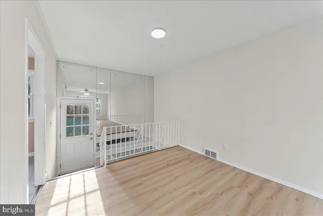 a view of a hallway with wooden floor and windows