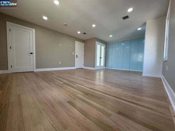 a view of an empty room with wooden floor