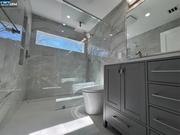 a bathroom with a toilet a sink and mirror