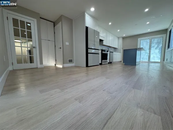 a view of empty room with wooden floor and windows