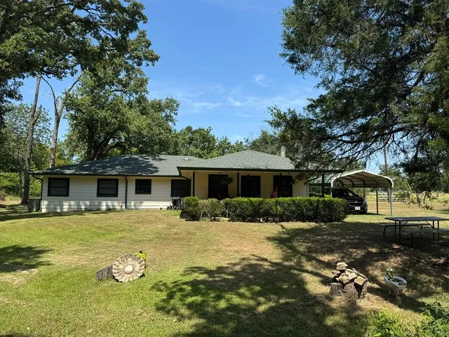 a front view of a house with yard patio and green space