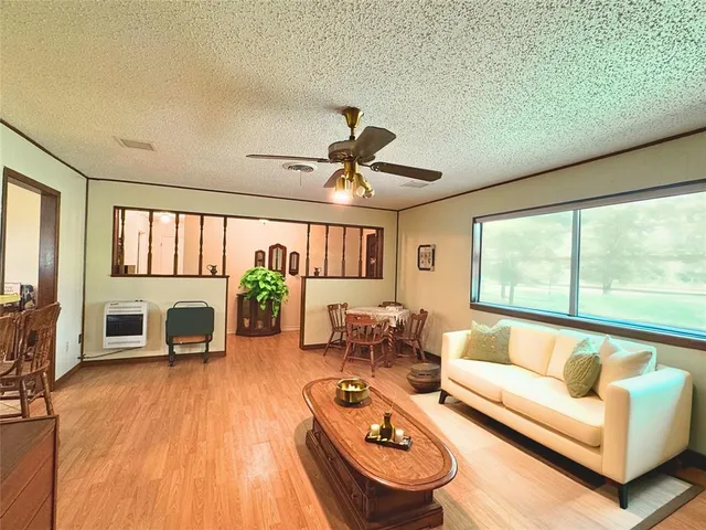 a living room with furniture and a large window with wooden floor
