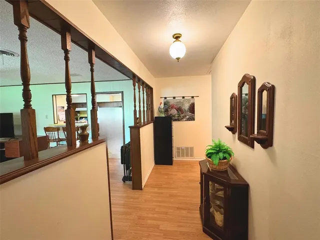 a hallway with a potted plant on the kitchen counter and a refrigerator