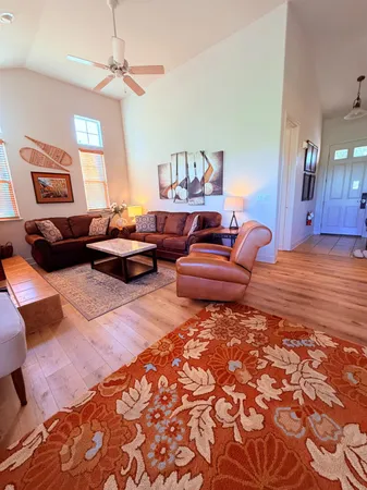 a living room with furniture a rug and a lamp