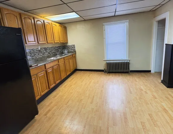 a view of a kitchen with wooden floor and electronic appliances