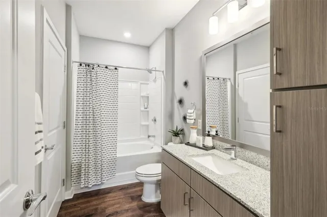 a bathroom with a granite countertop sink toilet and shower