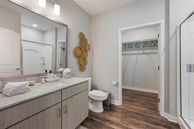a bathroom with a granite countertop sink a toilet and a mirror