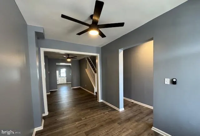 a view of a hallway with wooden floor and a ceiling fan