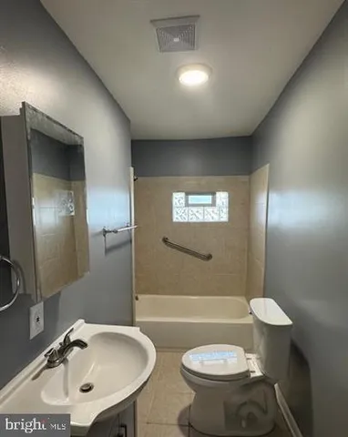 a bathroom with a sink a toilet and mirror
